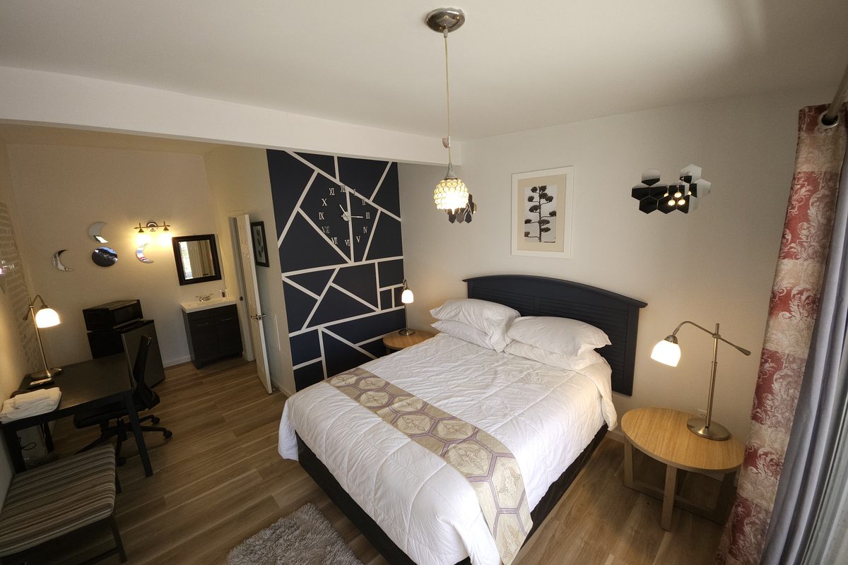 Modern guest room with accent wall and pendant lighting at Blazers Lodge