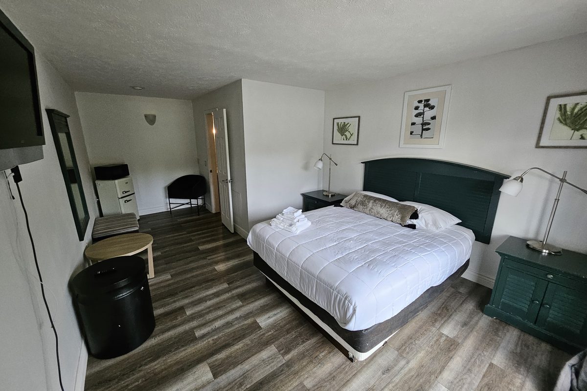 Clean guest room with work desk and green nightstands
